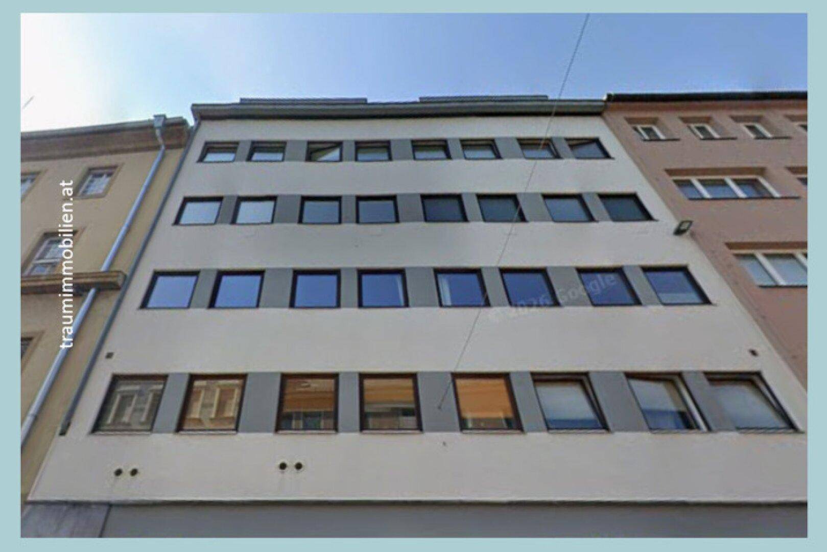 Mehrstöckiges Gebäude mit zahlreichen Fenstern und einer schlichten, modernen Fassade.