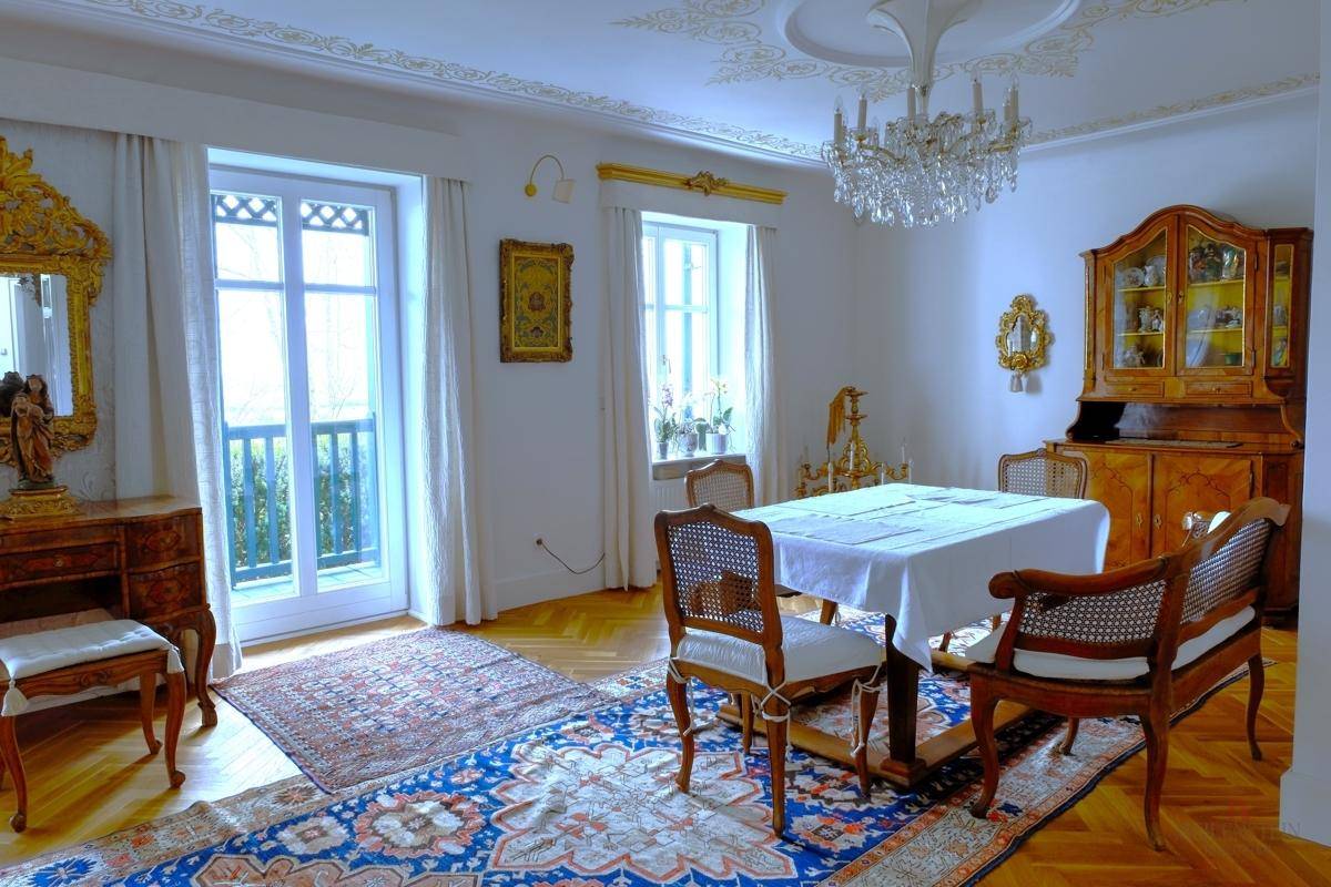Eleganter Essbereich mit Parkettboden, Kronleuchter und Zugang zum französischen Balkon.