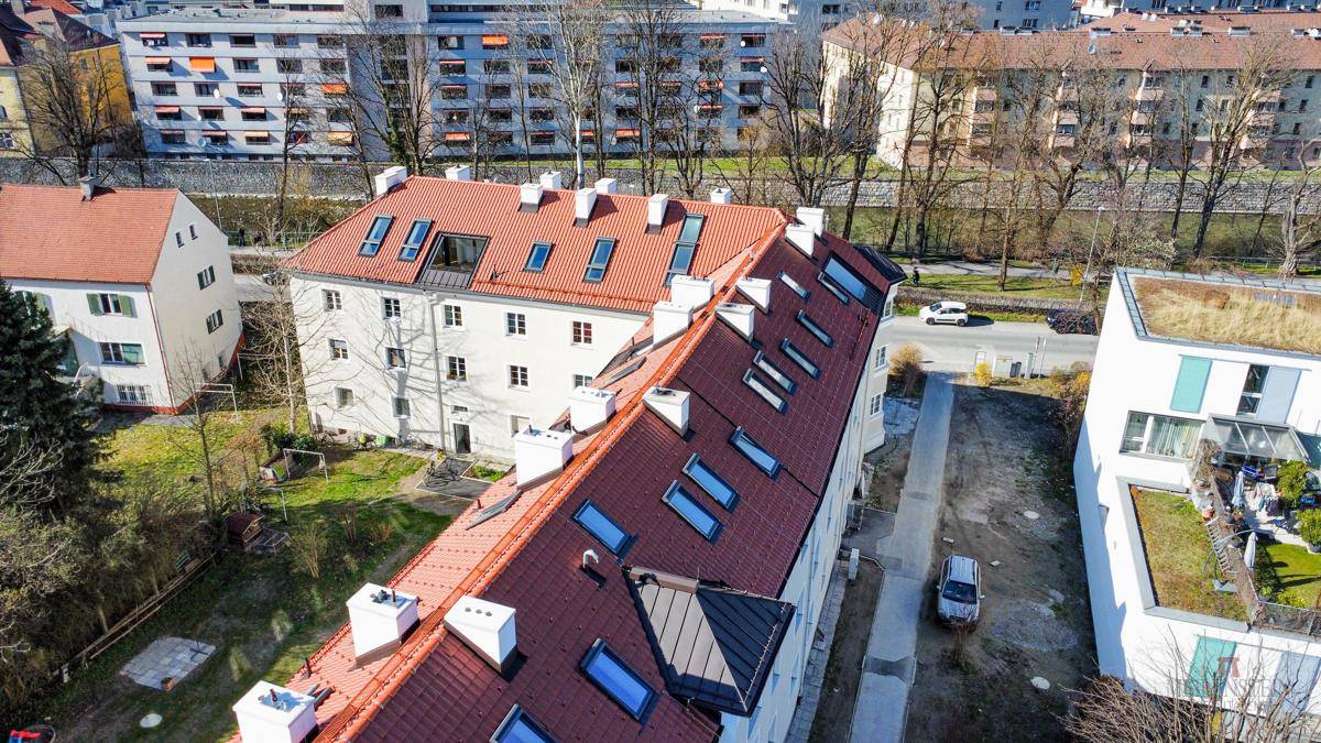 Luftaufnahme eines Wohngebäudes mit rotem Ziegeldach und zahlreichen Dachfenstern.