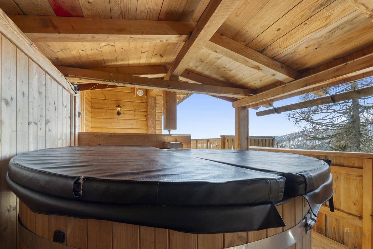 Überdachter Whirlpool auf dem Balkon mit Panoramablick auf die Berge.