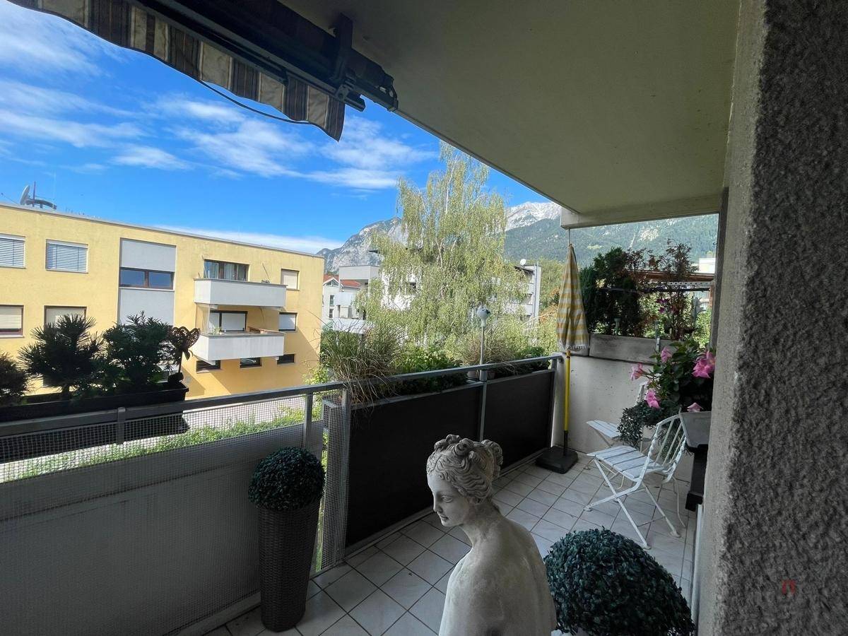Balkon mit Fliesenboden, Dekoration und weitem Blick auf die Berglandschaft.