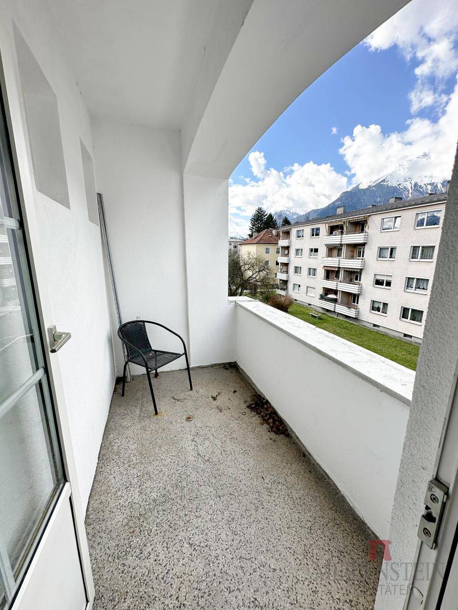 Kleiner Balkon mit Bergblick und einem Stuhl, ideal für entspannte Momente im Freien.