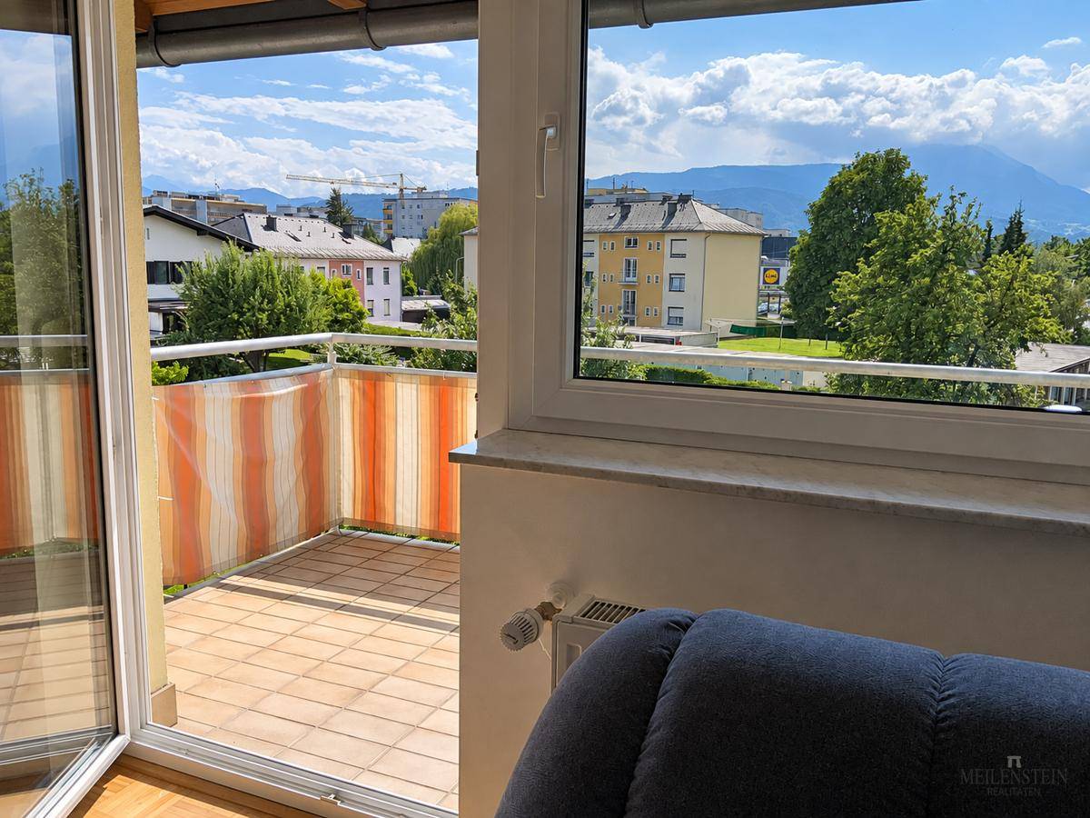 Blick aus dem Innenraum auf den Balkon und die weite Aussicht auf die Umgebung.