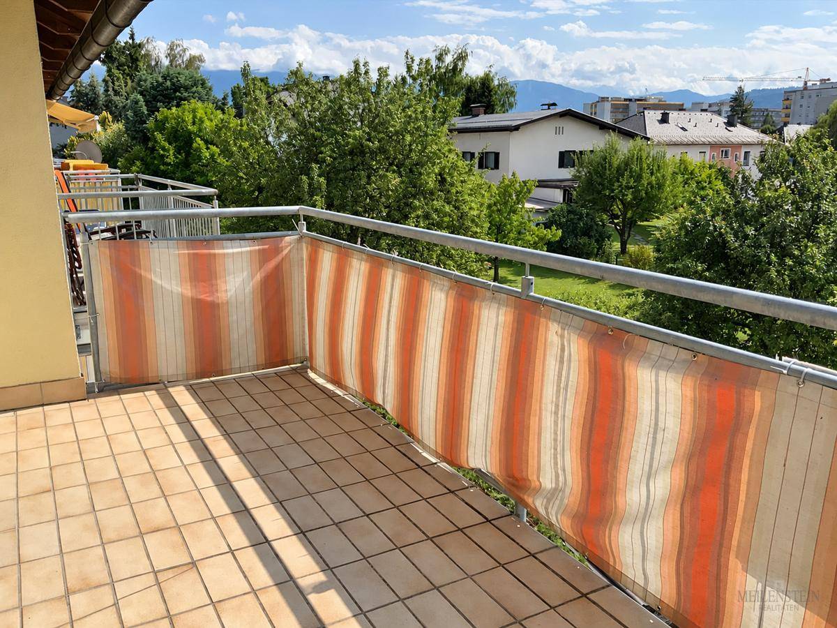 Geräumiger Balkon mit Fliesenboden und schöner Aussicht auf die umliegende Landschaft und Berge.