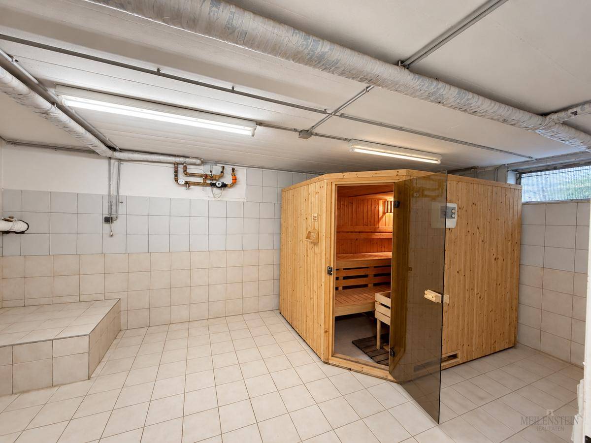 Geräumiger Kellerraum mit einer modernen Holzsauna und Fliesenboden, ideal zur Entspannung.