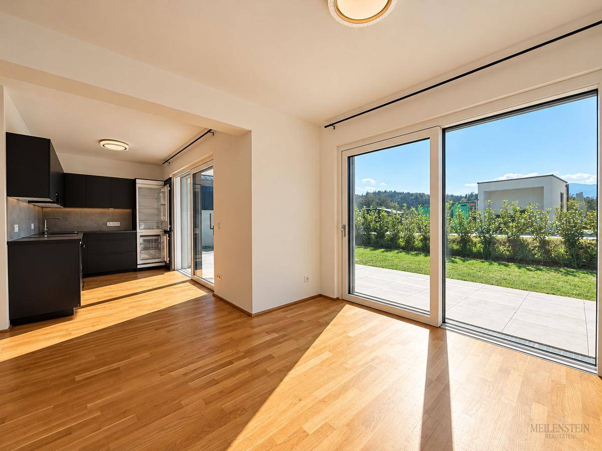 Offener Wohn-Essbereich mit integrierter Küche und direktem Zugang zur Terrasse.