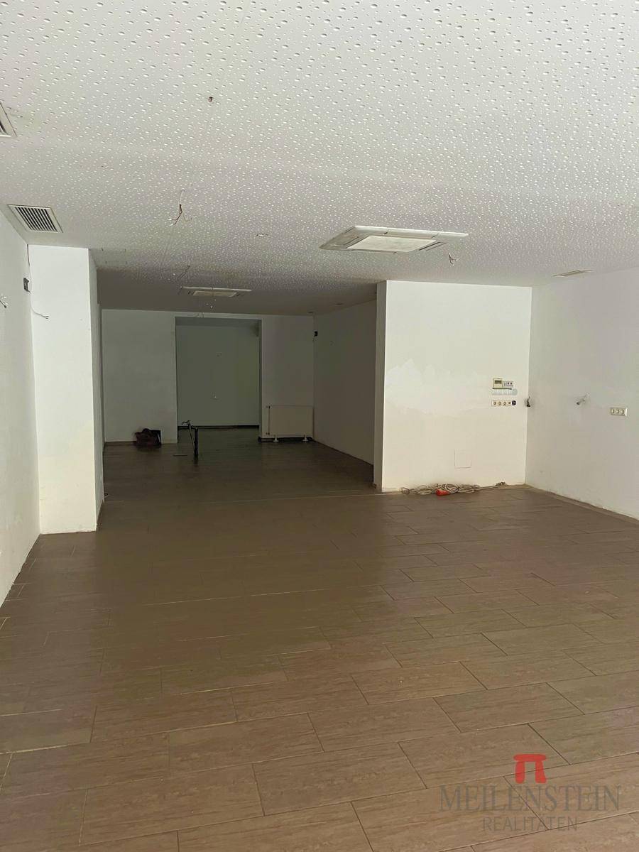 Großer, leerer Gewerberaum mit Fliesenboden und abgehängter Decke, ideal für verschiedene Geschäftsnutzungen.