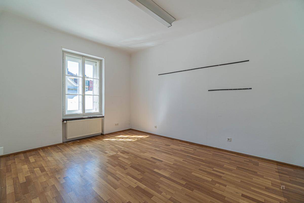 Ruhiger Raum mit Holzboden und einem Fenster, das ausreichend Tageslicht für konzentriertes Arbeiten bietet.