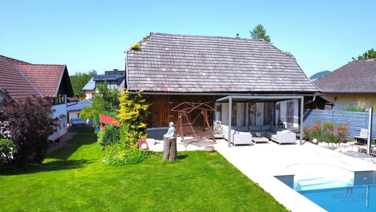 Übersicht des Anwesens mit großem Garten, Pool und gemütlichem Sitzbereich.