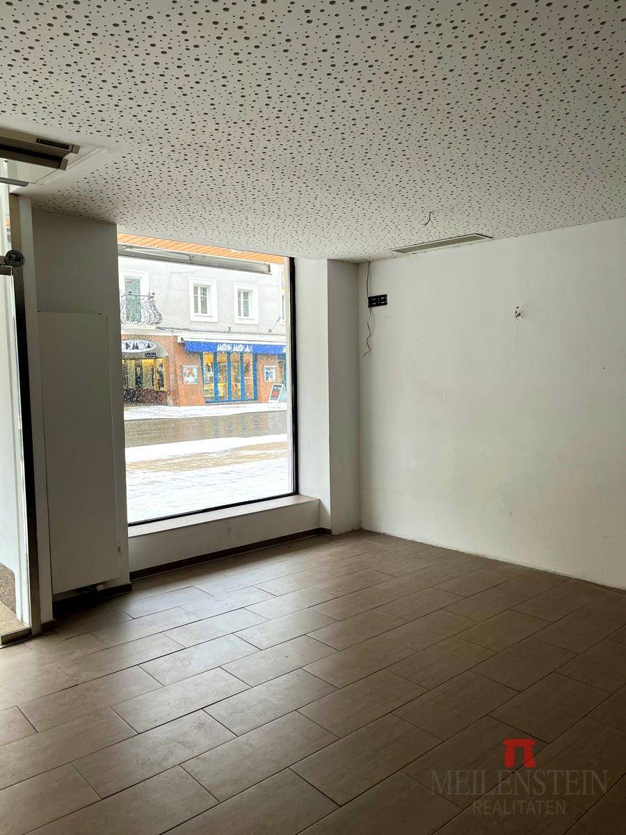 Heller Gewerberaum mit großen Fenstern, die einen Blick auf die verschneite Straße bieten.