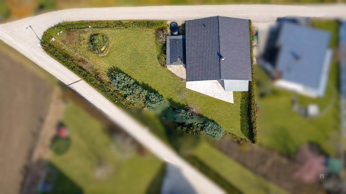 Draufsicht des Grundstücks mit Einfamilienhaus, Garten und angrenzenden Wegen in ländlicher Umgebung.