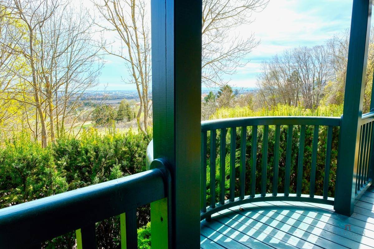Grüner Balkon mit weitem Blick über die Landschaft und Bäume.