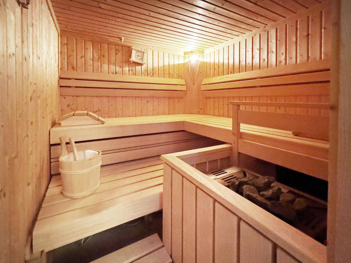 Traditionelle Holzsauna mit Bänken und Saunaofen für entspannende Momente der Erholung.