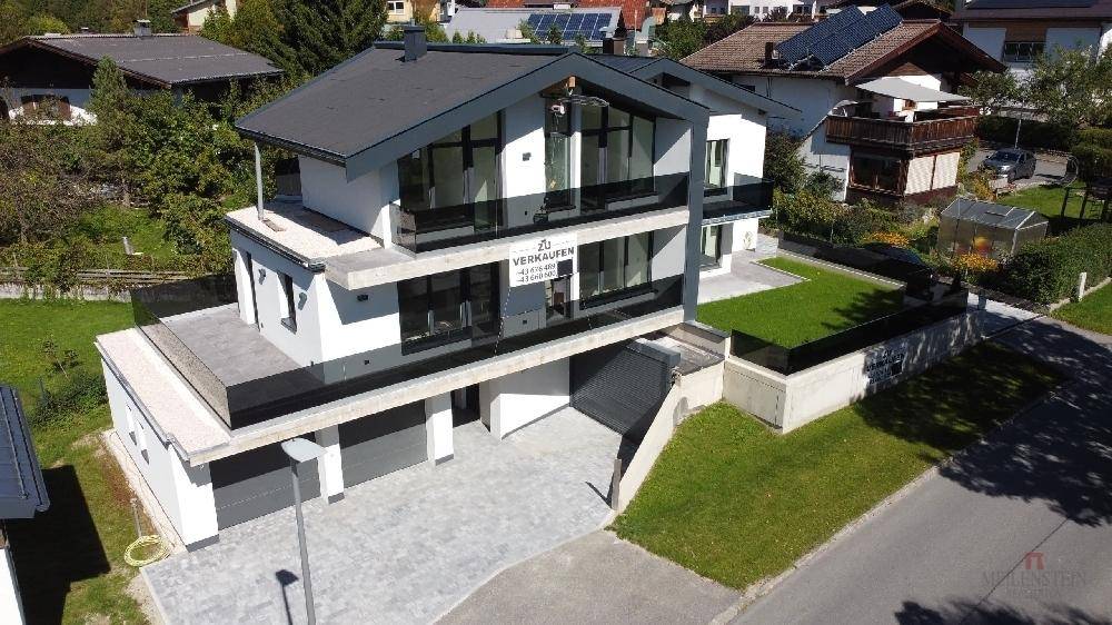 Neubau mit moderner Architektur, großen Fensterfronten und integrierter Tiefgarage.