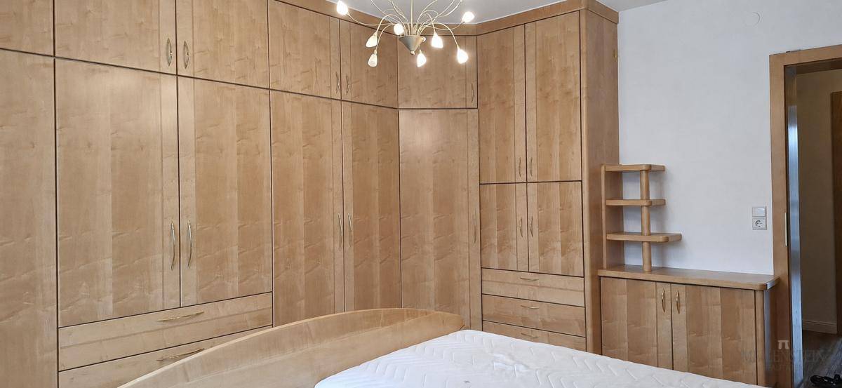 Schlafzimmer mit maßgefertigten Holzschränken, die viel Stauraum bieten und eine gemütliche Atmosphäre schaffen.