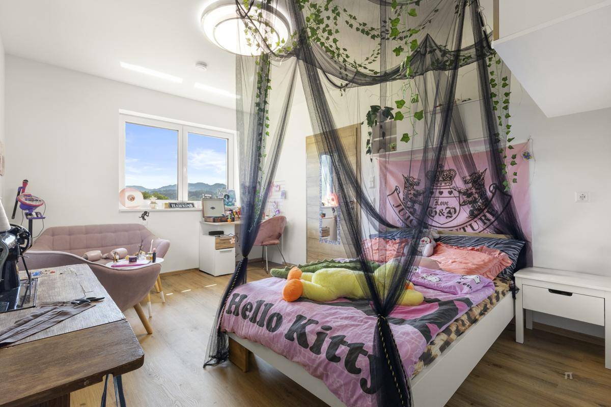 Kinderzimmer mit Himmelbett, Schreibtisch und Blick auf die umliegende Landschaft.