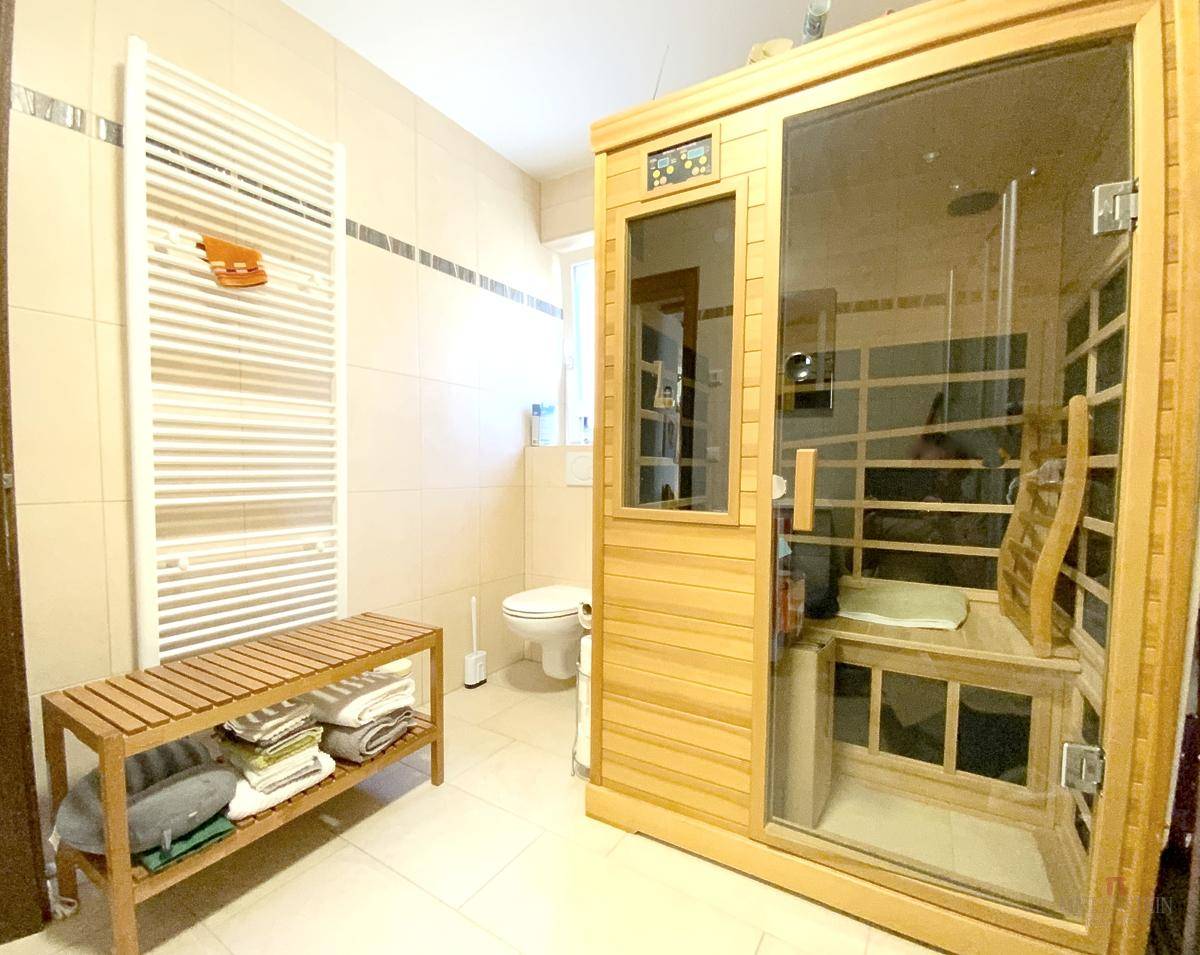 Geräumiges Badezimmer mit integrierter Sauna, beheiztem Handtuchhalter und WC.