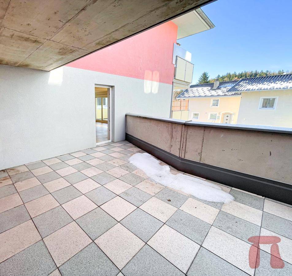 Geräumige Terrasse mit Fliesenboden und Blick auf die Umgebung.