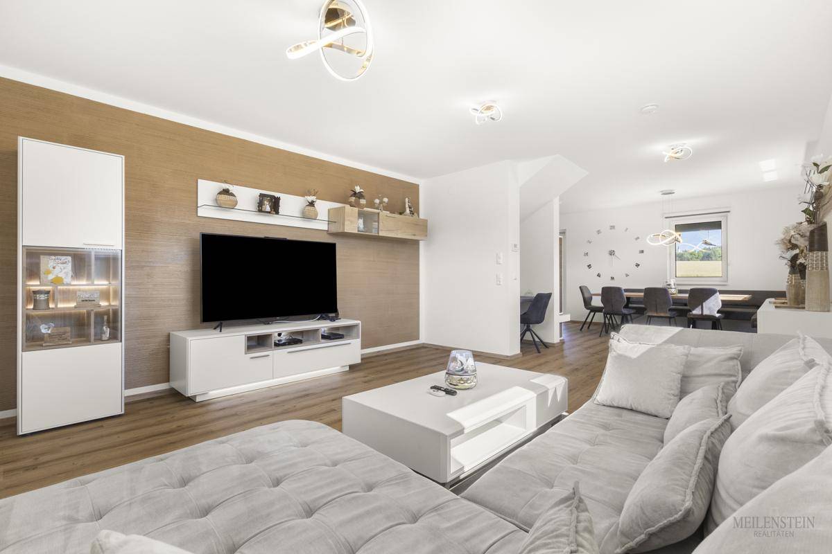 Gemütlicher Wohnbereich mit großem Sofa, modernem TV-Möbel und stilvoller Dekoration.