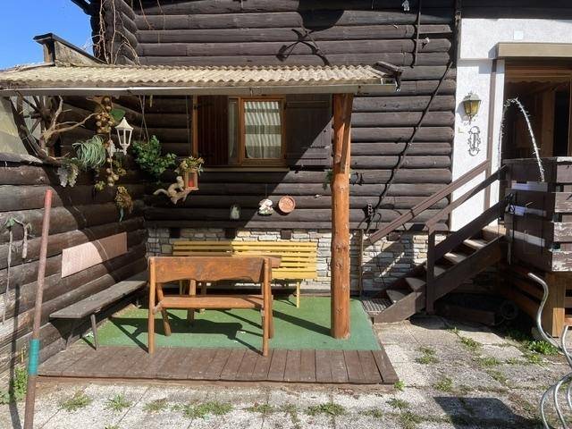 Überdachte Terrasse mit Holzbänken und rustikalem Charme am Holzhaus.