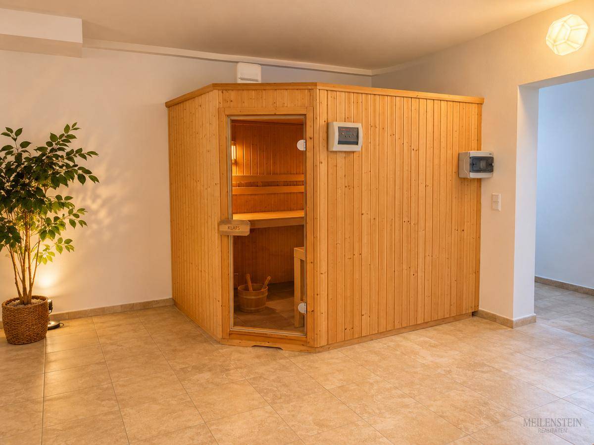 Geräumiger Wellnessbereich mit einer modernen Holzsauna und Fliesenboden für Entspannung.