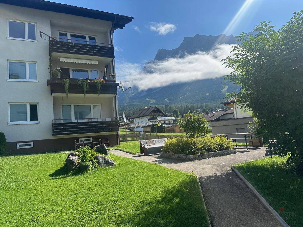 Mehrfamilienhaus mit Balkonen und Blick auf die majestätischen Berge.