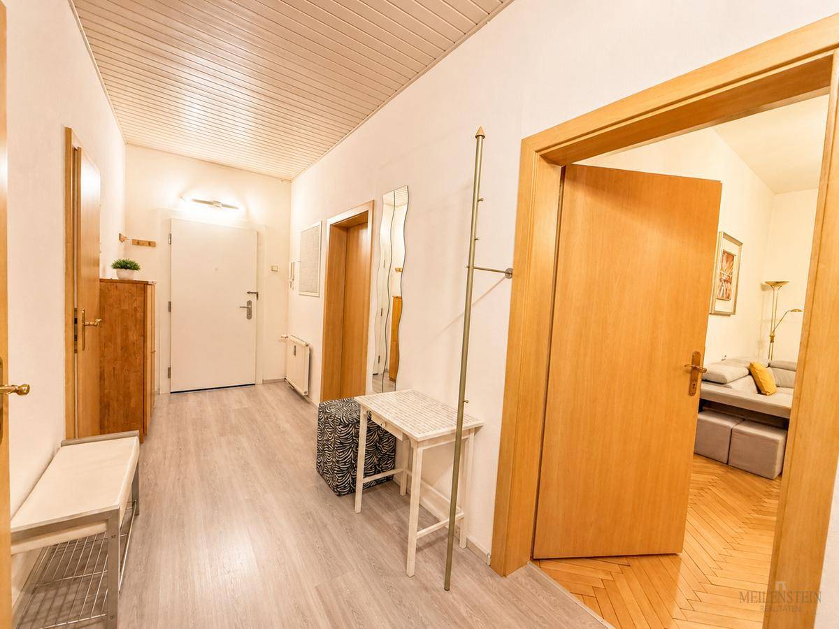 Heller Flur mit Laminatboden, Holztüren und Garderobe.
