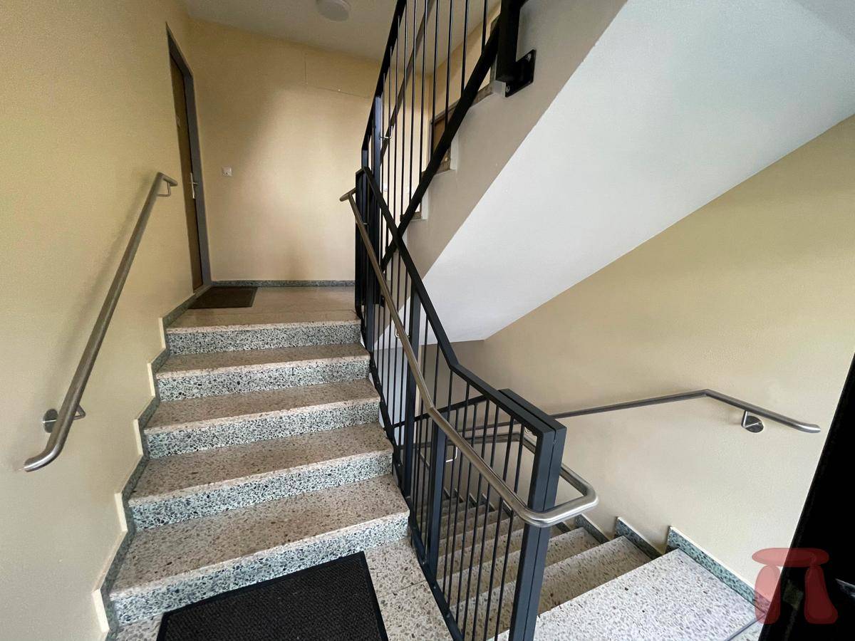 Treppenhaus mit robustem Terrazzoboden und stabilen Handläufen für sicheren Aufstieg in die oberen Etagen.