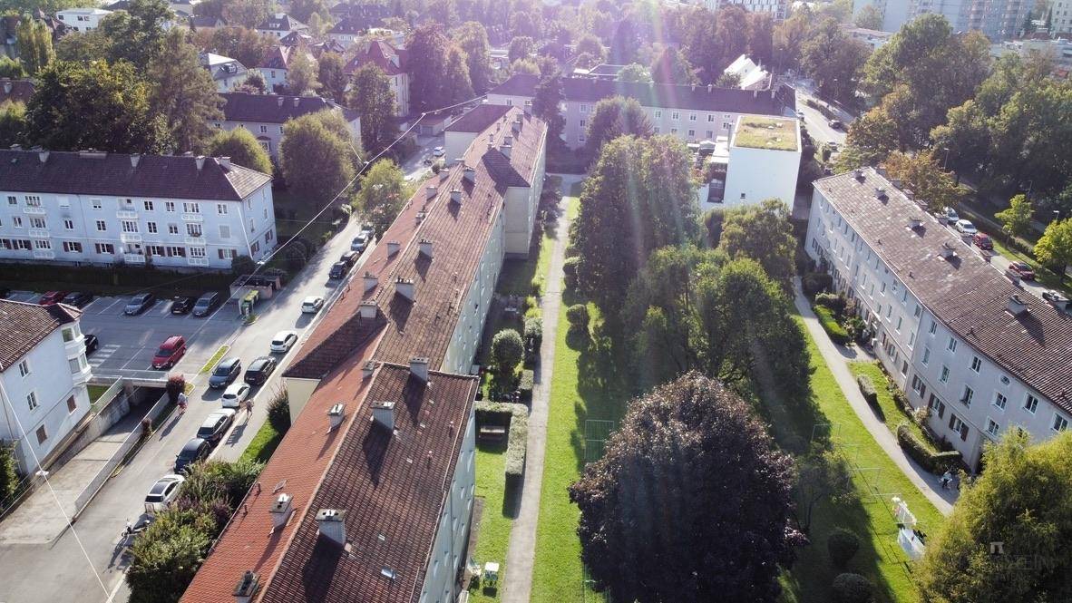 Luftaufnahme einer Wohnsiedlung mit viel Grünfläche und Mehrfamilienhäusern.