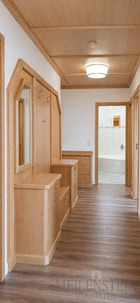 Geräumiger Flur mit Holzvertäfelung, integrierter Garderobe und Zugang zu weiteren Räumen.