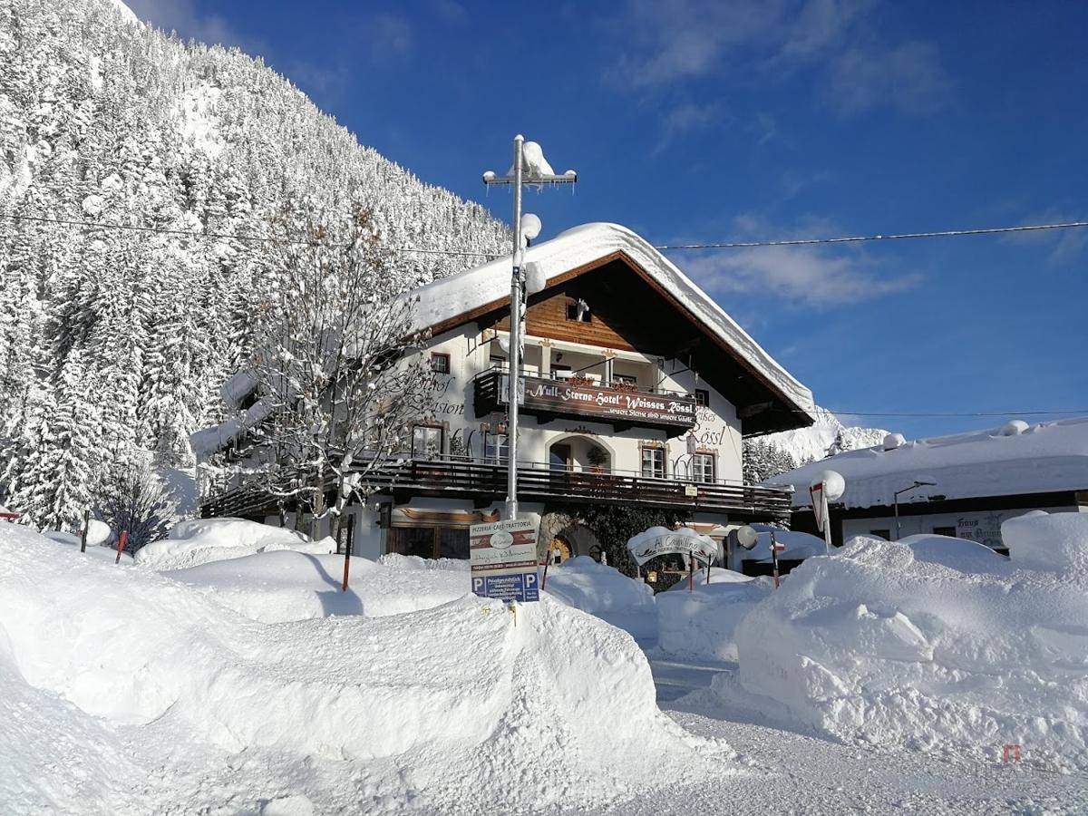 Malerisches Gasthaus in den Alpen, umgeben von tiefem Schnee und verschneiten Bergen.