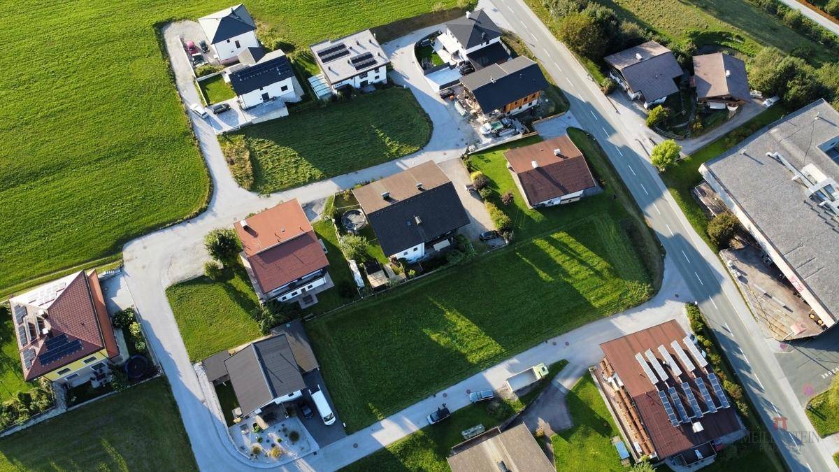 Panoramablick aus der Luft auf eine Wohngegend mit Einfamilienhäusern und angrenzenden Feldern.