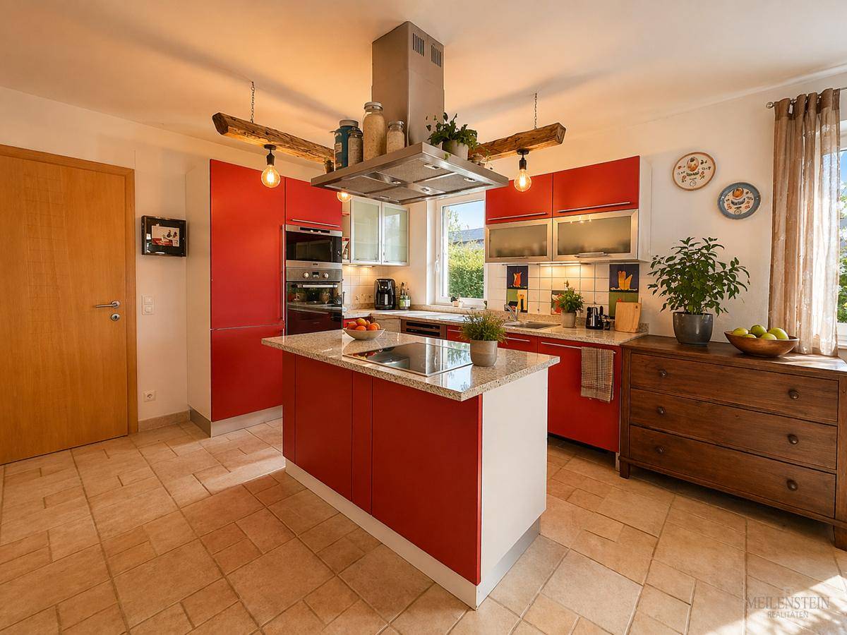 Moderne Küche mit roten Schränken, Kücheninsel und Granitarbeitsplatte, gut beleuchtet durch ein Fenster.