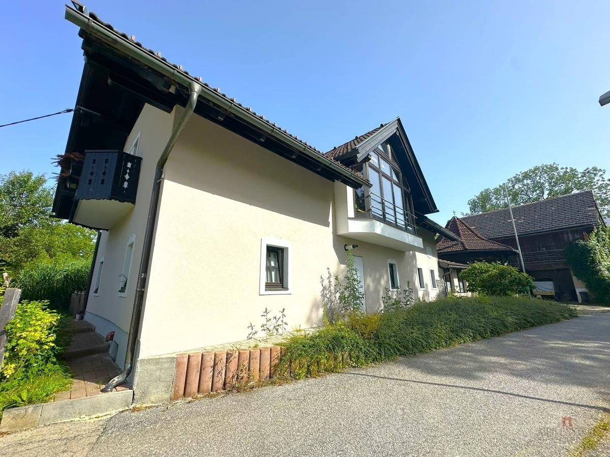Seitenansicht des Hauses mit Balkon und gepflegter Fassade.