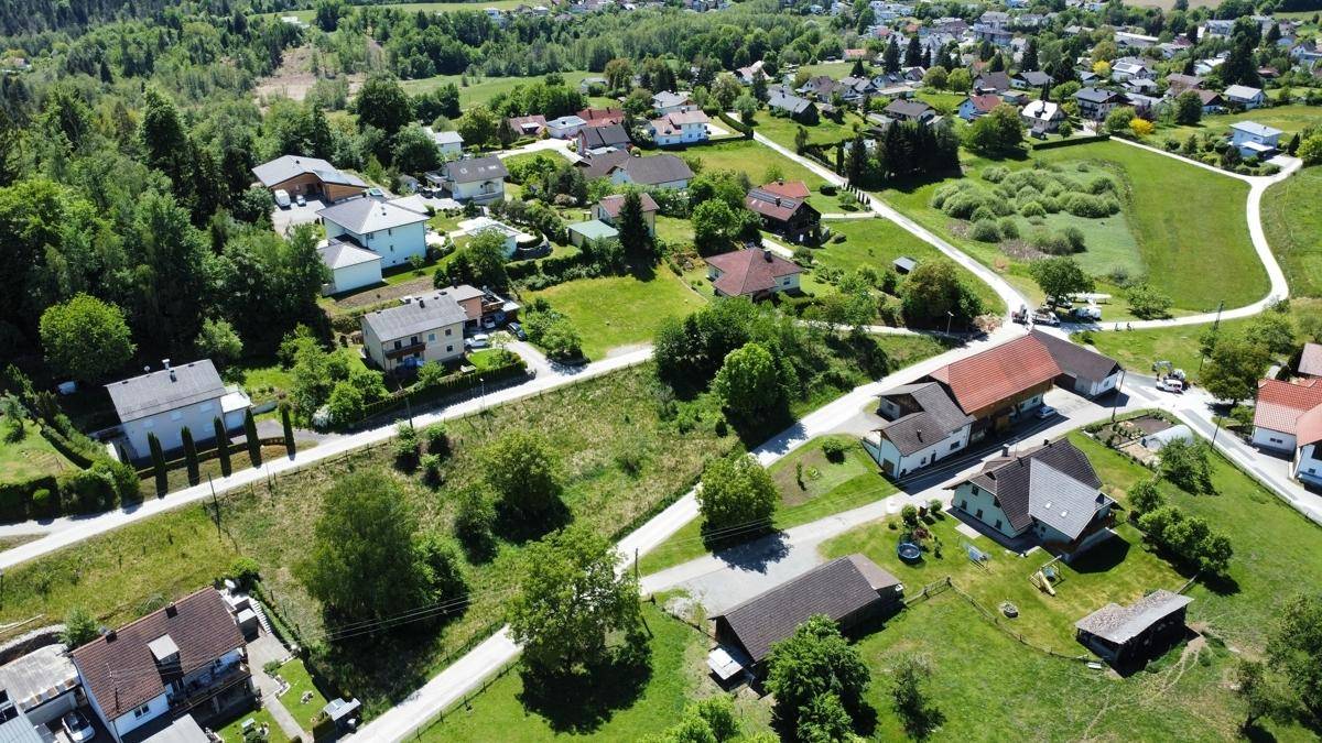 Panoramablick aus der Luft auf eine ländliche Wohngegend mit vielen Grünflächen und verstreuten Häusern.