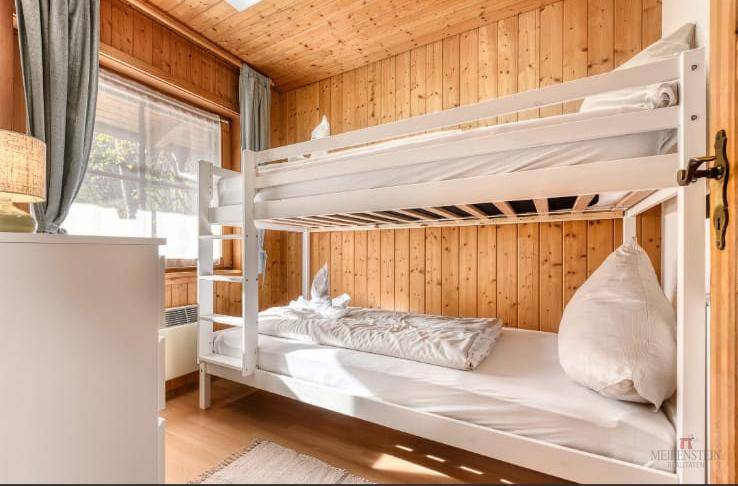 Kinderzimmer mit Etagenbett und Holzwänden, ideal für Familien.