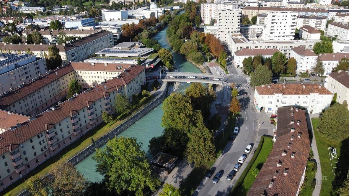 Luftaufnahme einer städtischen Flusslandschaft mit Brücken und umliegenden Wohngebäuden.