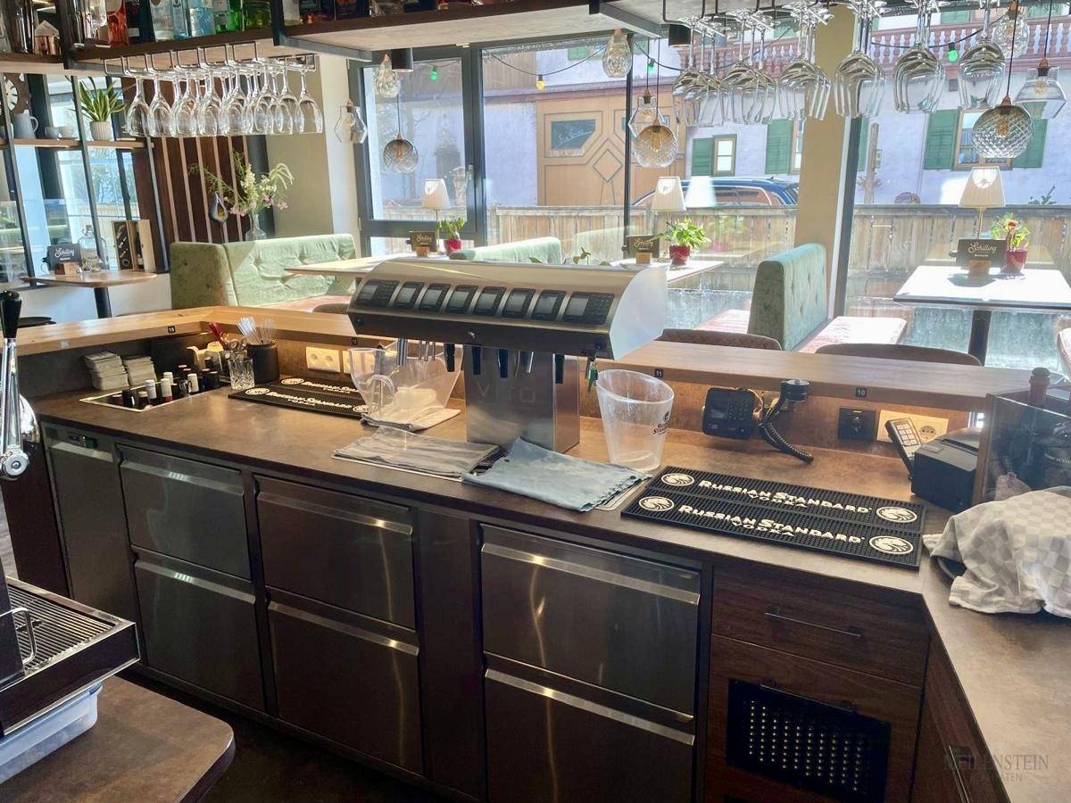 Arbeitsbereich der Bar mit Zapfanlage, Kühlschränken und Vorbereitungsflächen für Getränke.