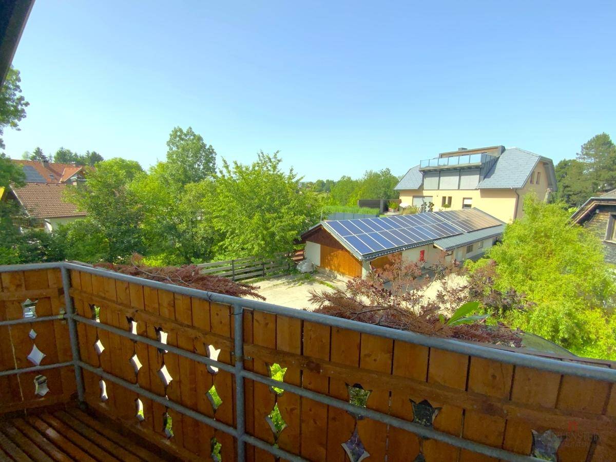 Blick vom Balkon auf die Nachbarschaft mit viel Grün und Solaranlagen.
