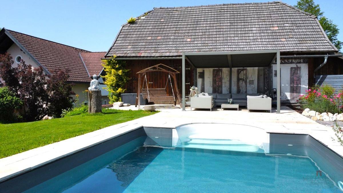 Attraktiver Gartenbereich mit Pool, Liegeflächen und überdachtem Sitzbereich.