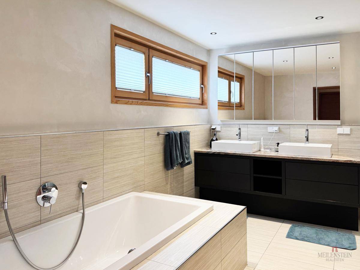 Modernes Badezimmer mit Doppelwaschbecken, Badewanne und großem Spiegelschrank.