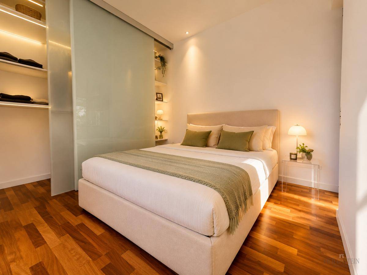 Modernes Schlafzimmer mit Holzboden und integriertem Kleiderschrank hinter einer Glasschiebetür.