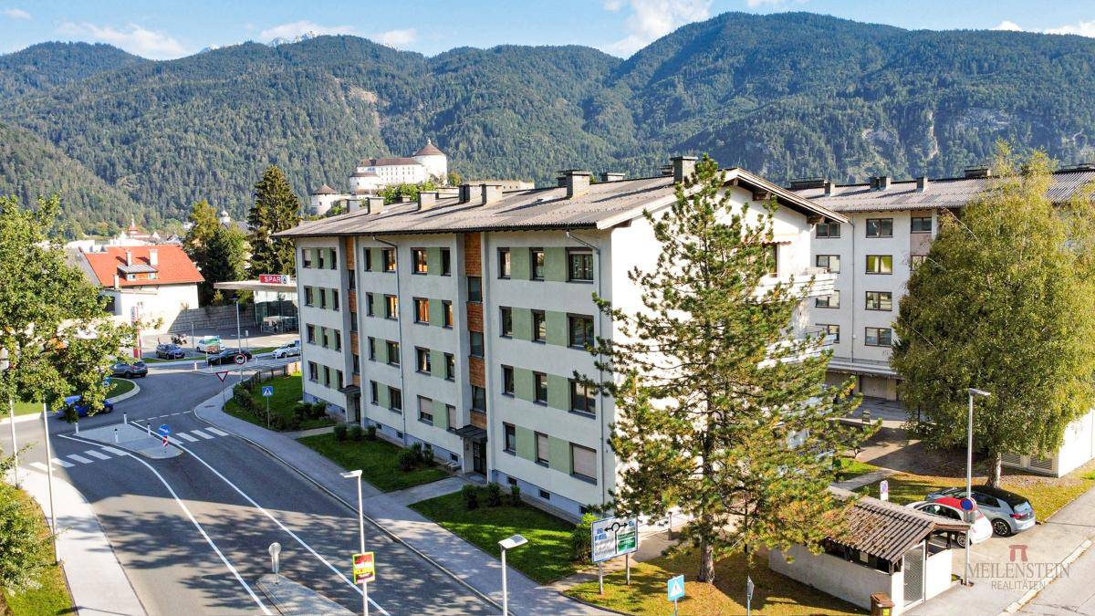 Luftaufnahme eines Wohngebäudes in bergiger Umgebung mit viel Grün.