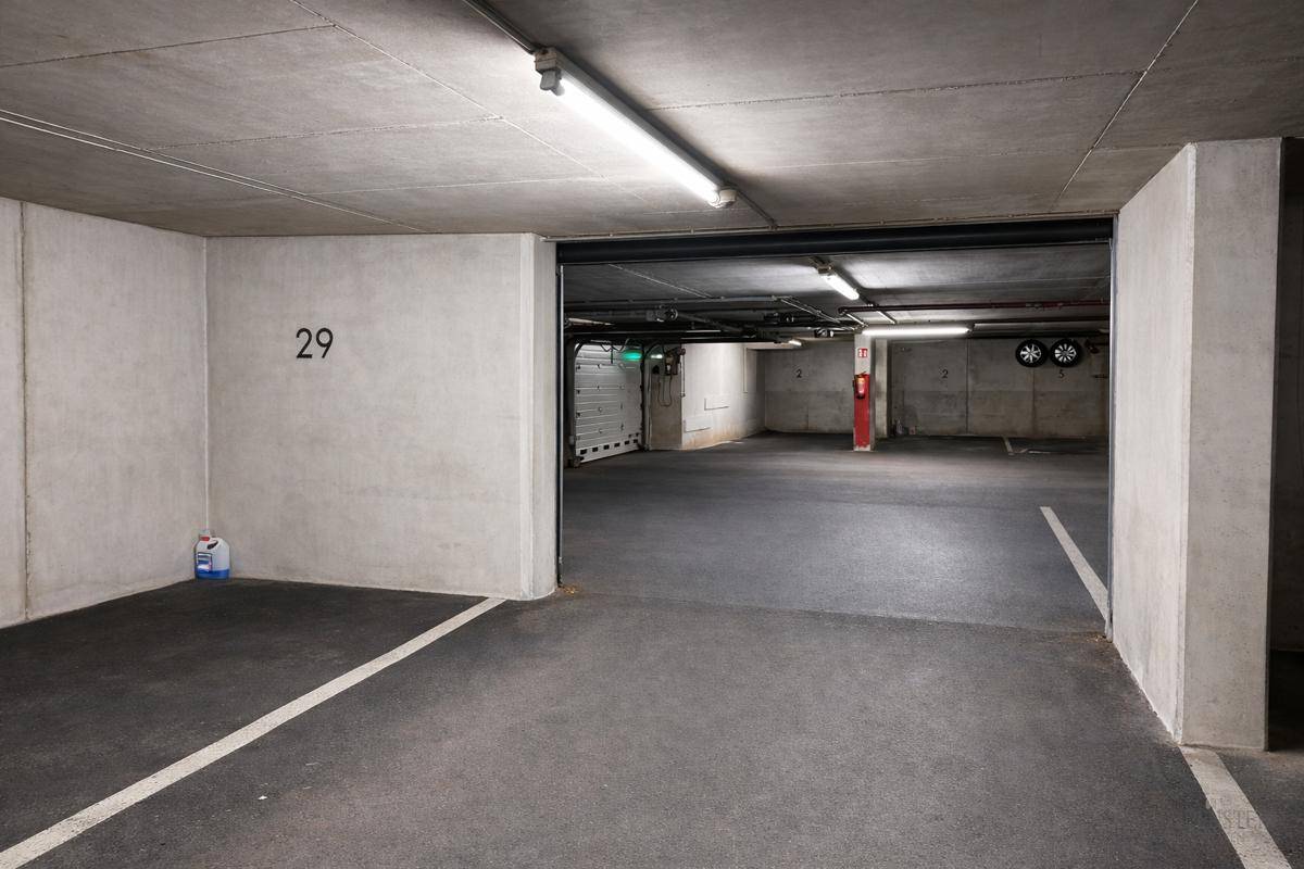 Heller Stellplatz Nummer 29 in einer Tiefgarage mit Betonwänden und Blick auf weitere Parkflächen.