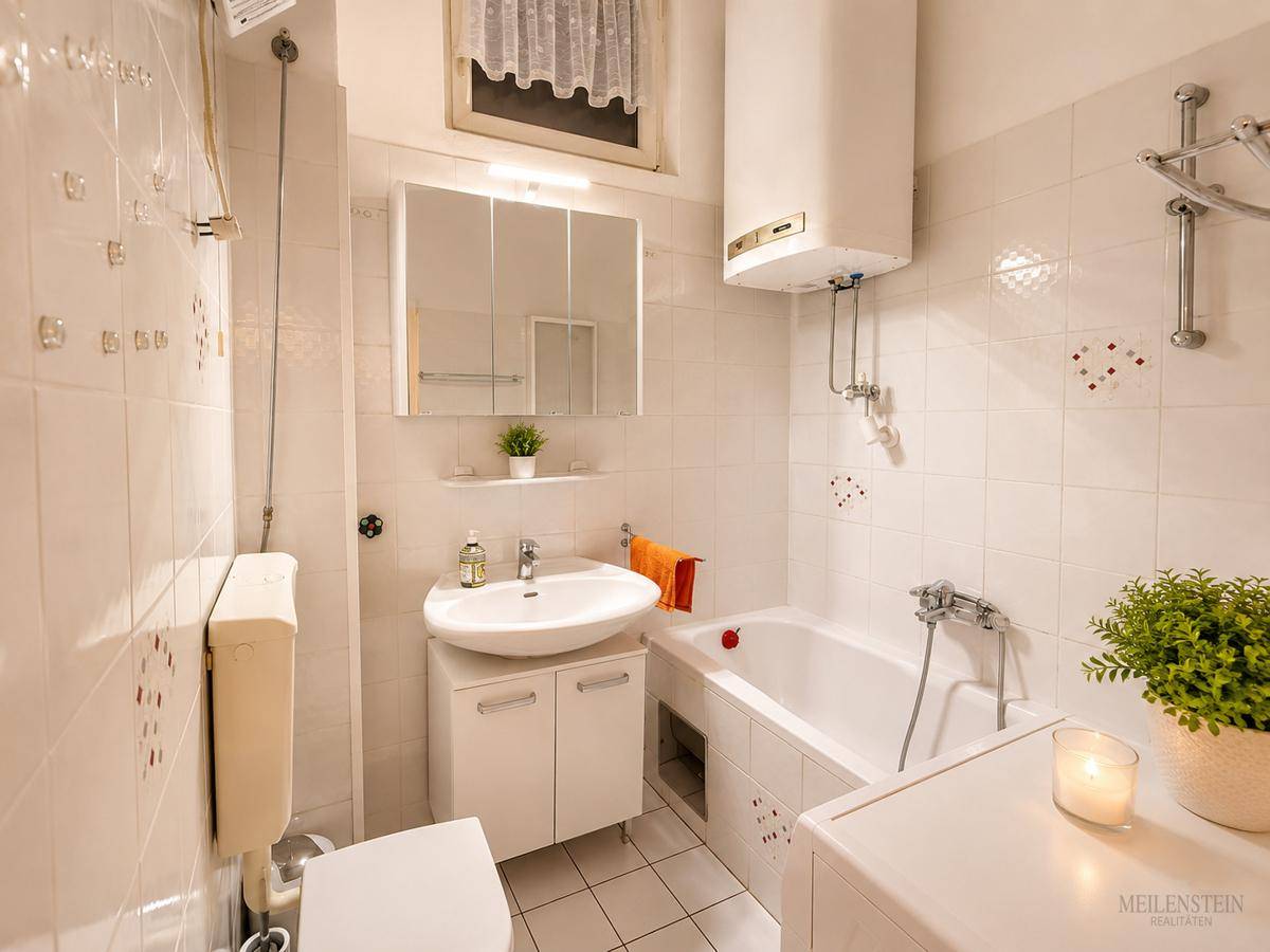 Badezimmer mit weißen Fliesen, Badewanne, Waschbecken und Fenster.