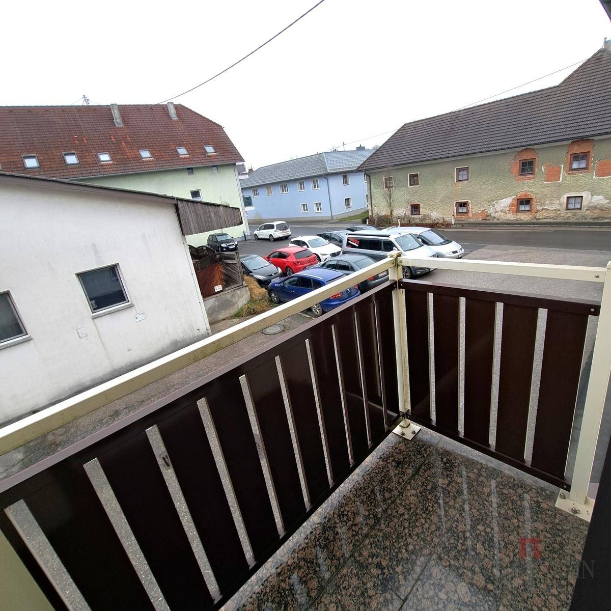 Kleiner Balkon mit Blick auf die umliegenden Häuser und die Straße.