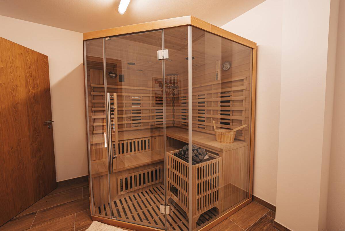 Moderne Sauna mit Holzbänken und Glasfront für Entspannung und Wellness.