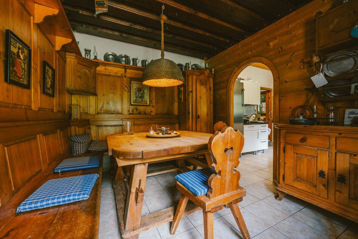 Gemütlicher Essbereich im alpenländischen Stil mit Holztäfelung, Holzbalkendecke und traditionellen Möbeln.