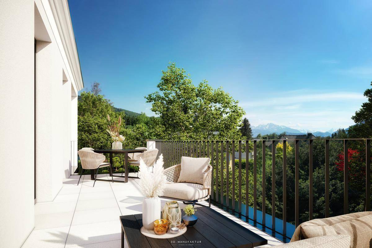 Geräumiger Balkon mit modernen Gartenmöbeln und weitem Blick ins Grüne und auf Berge.
