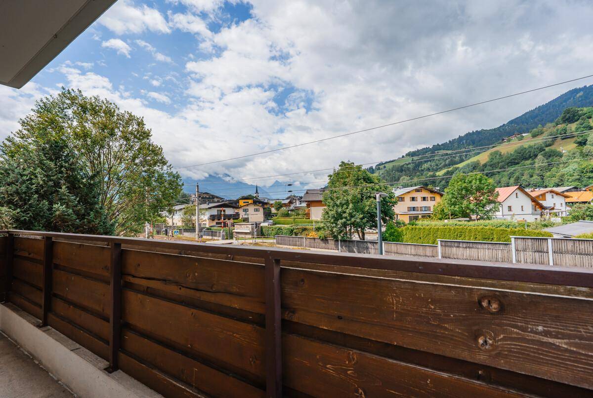 Balkon mit Holzbalken und weitem Blick auf die umliegende Berglandschaft.